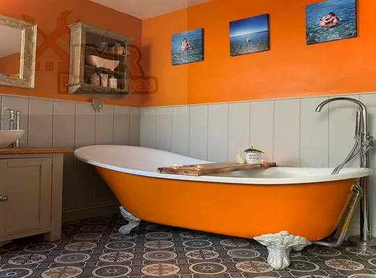 Baño naranja con bañera exenta